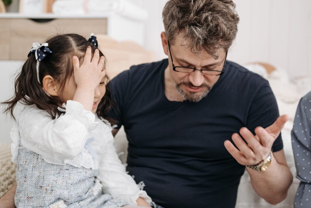 A man talking with a young girl sitting beside him