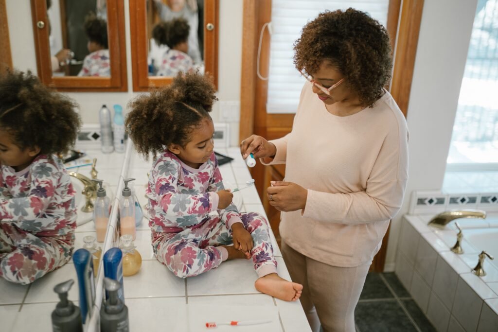 Parent helping a young child get dressed in the bathroom