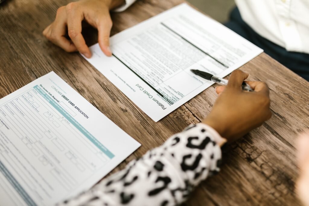 Two people reviewing printed forms at a wooden table